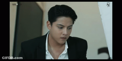 Man In Suit Sitting In Front Of ABS CBN Screen GIF