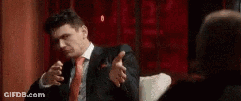 Man In Suit Sitting In Front Of Another Man GIF