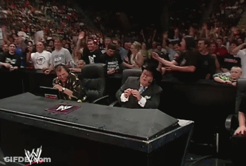 Man In Suit Sitting In Front Of Crowd With W Logo GIF