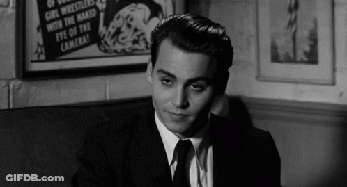 Man In Suit Sitting In Front Of Eye Of Camera Poster GIF