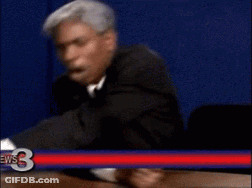 Man In Suit Sitting In Front Of News 3 Sign GIF