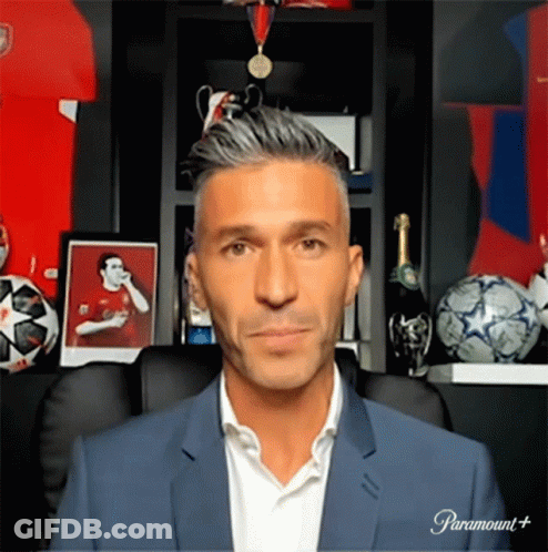 Man In Suit Sitting In Front Of Paramount Plus Sign GIF