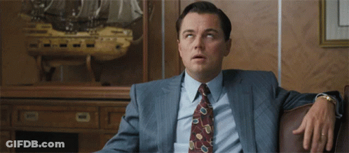 Man In Suit Sitting In Front Of Ship Model GIF