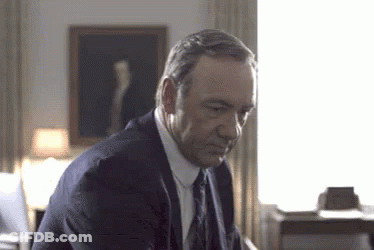 Man In Suit Sitting In Front Of Window GIF
