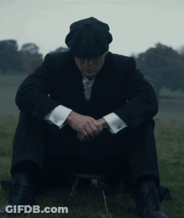 Man In Suit Sitting In Grass With Head Down GIF