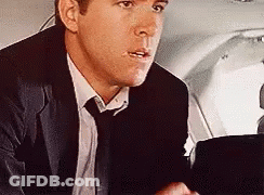 Man In Suit Sitting In Plane Back Seat GIF