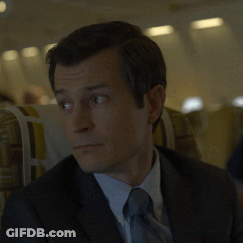 Man In Suit Sitting In Plane GIF