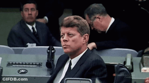 Man In Suit Sitting In Row Of Chairs GIF