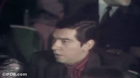 Man In Suit Sitting In Stadium GIF