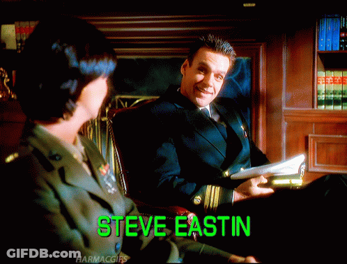 Man In Suit Sitting Next To Woman With Steve Eastin Displayed GIF