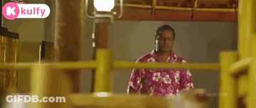 Man In Suit Sitting Next To Yellow Fence GIF