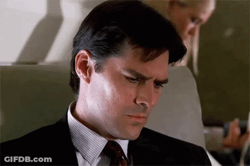 Man In Suit Sitting On Airplane Looking Down GIF