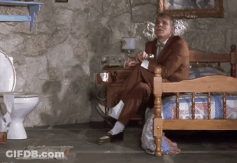 Man In Suit Sitting On Bed In Bathroom GIF
