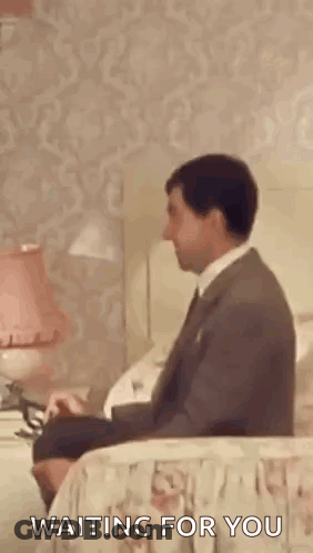 Man In Suit Sitting On Bed Waiting GIF