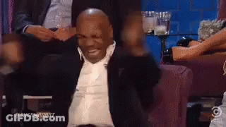 Man In Suit Sitting On Couch Arms Outstretched Smiling GIF