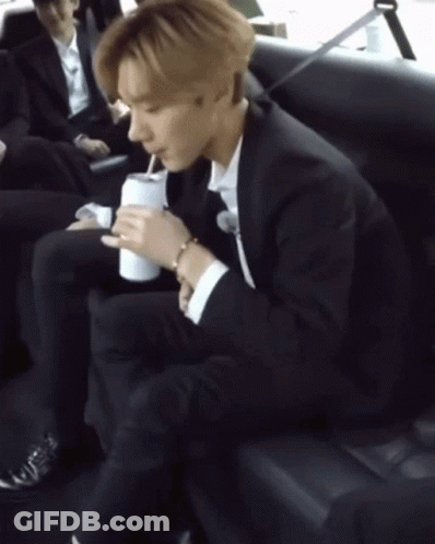 Man In Suit Sitting On Couch Holding Soda GIF