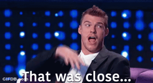 Man In Suit Sitting On Couch Saying That Was Close GIF