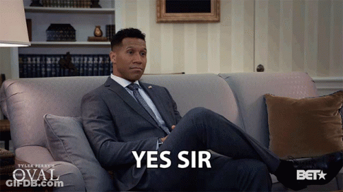 Man In Suit Sitting On Couch Saying Yes Sir GIF