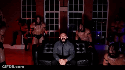 Man In Suit Sitting On Couch Surrounded By Men GIF