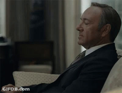 Man In Suit Sitting On Couch With Eyes Closed And Hands Folded GIF
