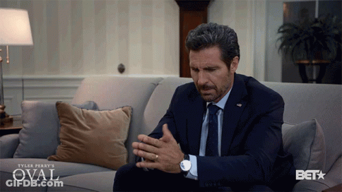 Man In Suit Sitting On Couch With Oval GIF