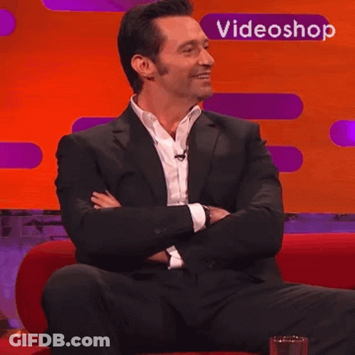 Man In Suit Sitting On Red Couch With Videoshop Logo GIF