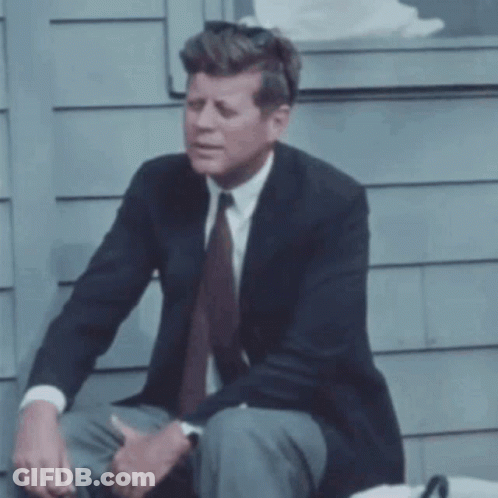 Man In Suit Sitting On Sidewalk GIF