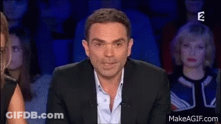 Man In Suit Sitting On Stage GIF