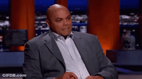 Man In Suit Sitting On Stage With Hands Folded GIF