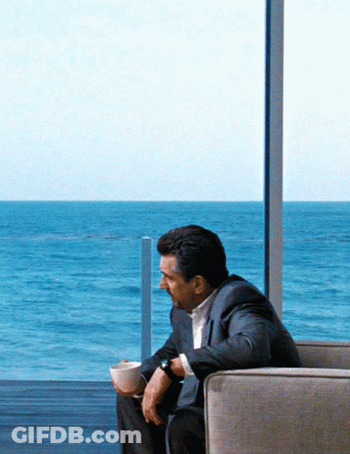 Man In Suit Sitting With Coffee GIF