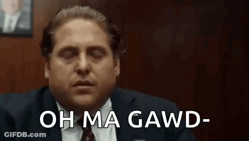 Man In Suit Sitting With Eyes Closed Saying Oh Ma Gawd GIF