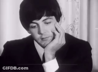Man In Suit Sitting With Hand On Chin GIF