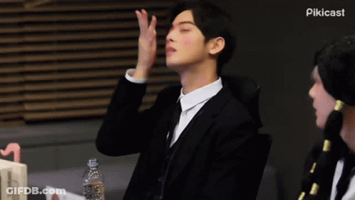 Man In Suit Sitting With Hand On Face Eyes Closed GIF
