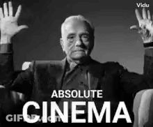 Man In Suit Sitting With Hands Up GIF