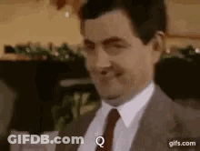 Man In Suit Smiling And Making A Face GIF