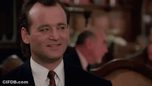 Man In Suit Smiling At Table GIF