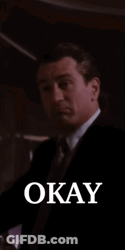 Man In Suit Smiling Holding Glass Saying Okay GIF