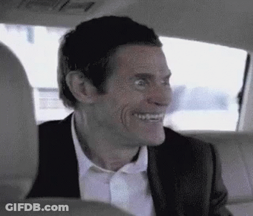 Man In Suit Smiling In Back Seat Of Car GIF