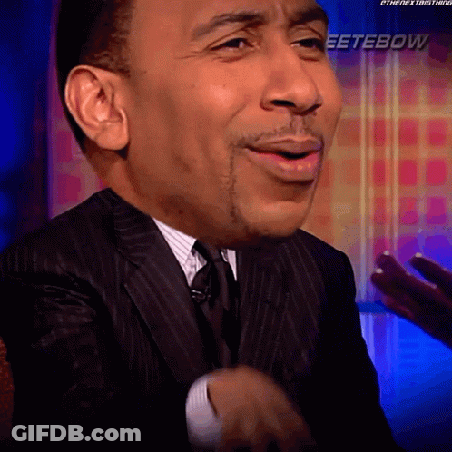 Man In Suit Smiling In Front Of Eeterbow Sign GIF