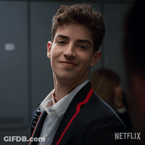 Man In Suit Smiling In Front Of Netflix Sign GIF