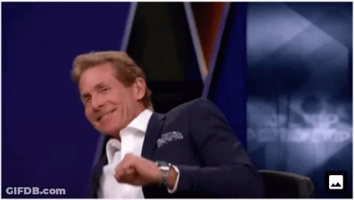 Man In Suit Smiling In Front Of Purple Background GIF