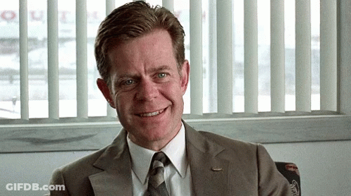 Man In Suit Smiling In Front Of Window Saying Queen GIF