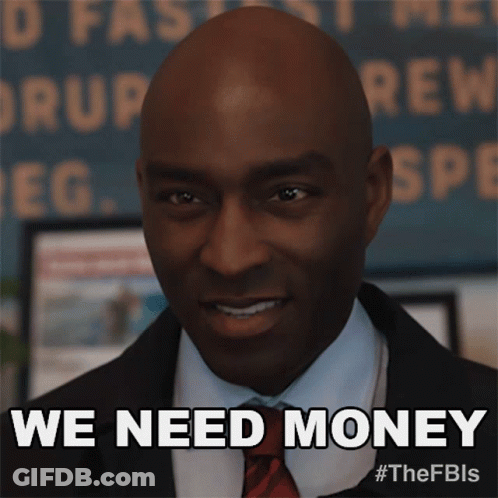 Man In Suit Smiling Says We Need Money GIF