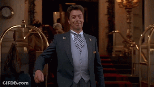 Man In Suit Smiling With Lapel Pin GIF