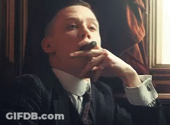 Man In Suit Smoking Cigar By Window GIF