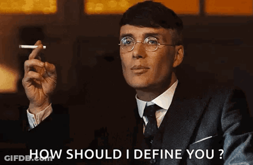 Man In Suit Smoking Cigarette Asking How To Define You GIF