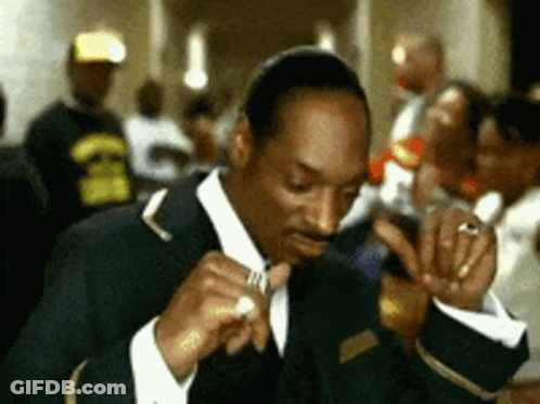 Man In Suit Smoking Cigarette In Crowded Room GIF