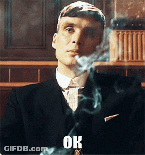 Man In Suit Smoking Cigarette Saying Ok GIF