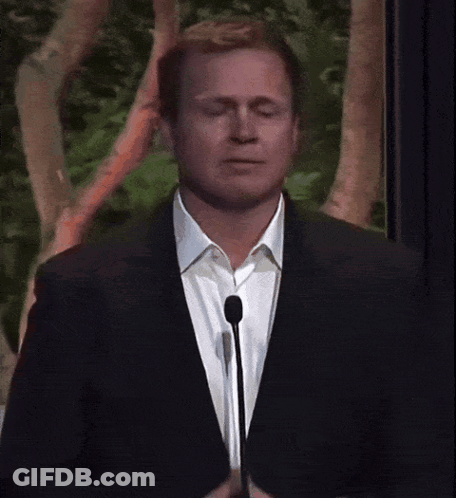 Man In Suit Speaking Into Microphone GIF