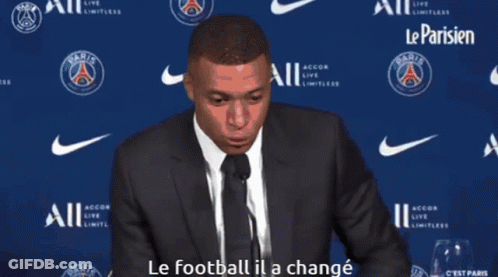 Man In Suit Speaking Into Microphone Le Football Il A Changé GIF